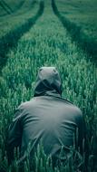 hooded man in the green field