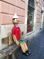 Sitting wooden sculpture on a bench