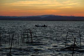 scenery of the boats in sea at sunset
