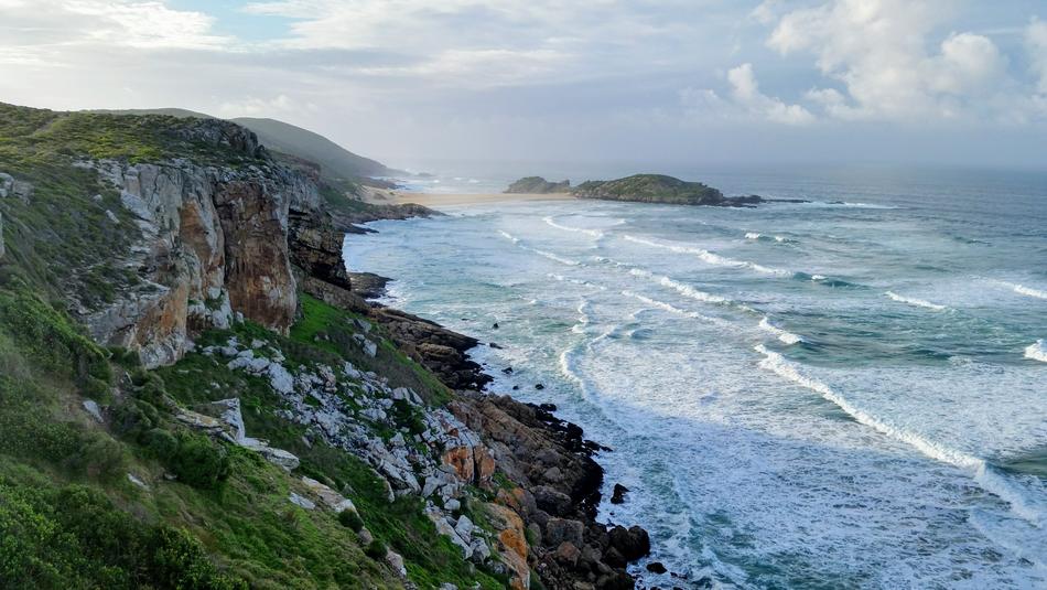 the rocks are green with big waves