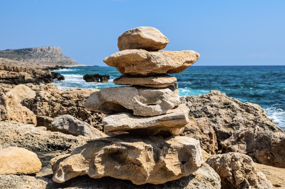 a stone tower on the beach by the ocean