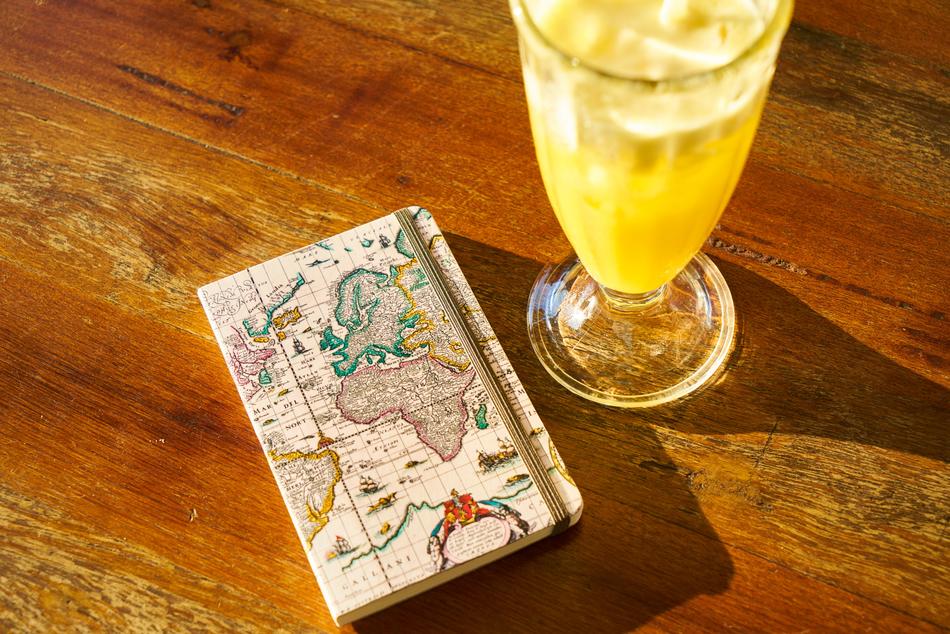 a glass of homemade lemonade and a notebook on the table