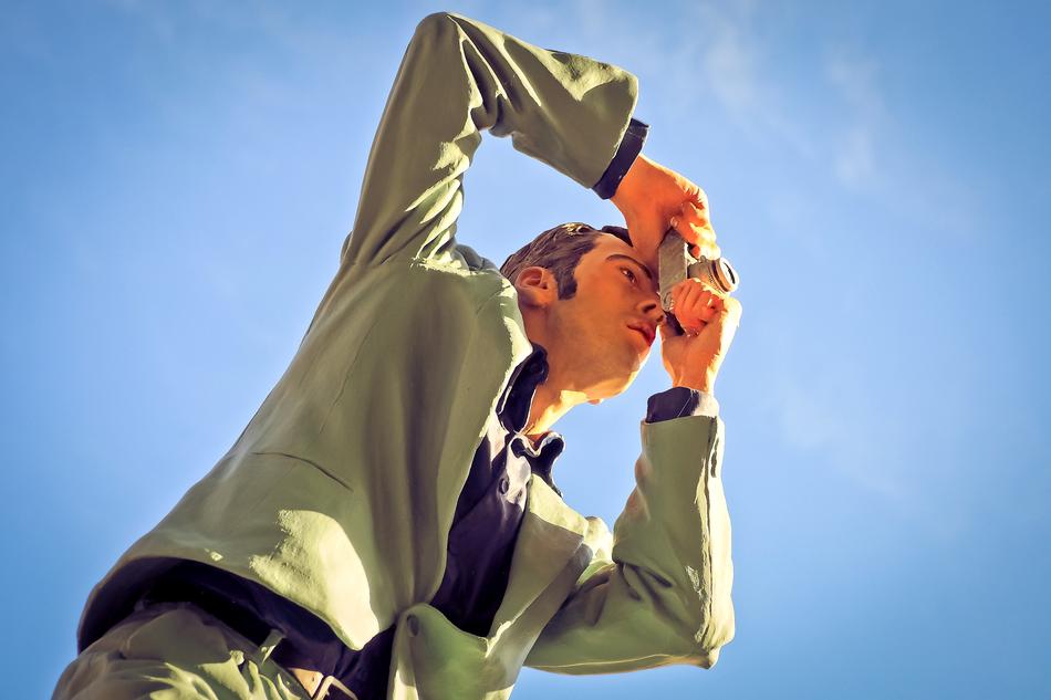 a man with a camera against the blue sky