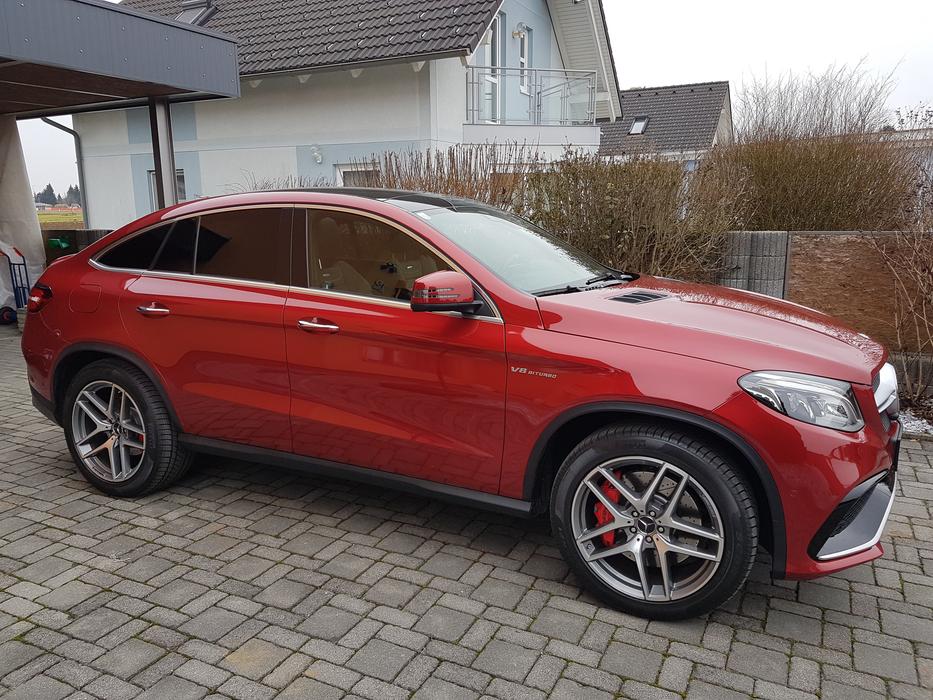 a beautiful red car in front of the house