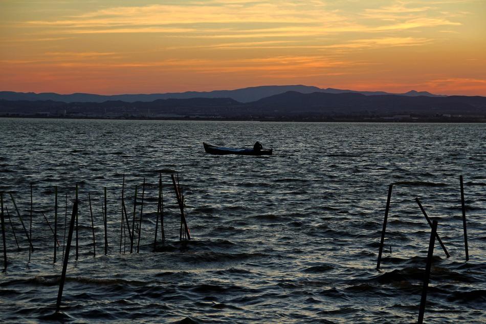scenery of the boats in sea at sunset