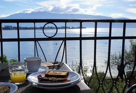 meal on table on terrace in front of sea, Italy, Garda