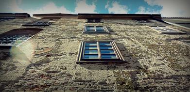 photo of windows on the old facade of the building bottom view
