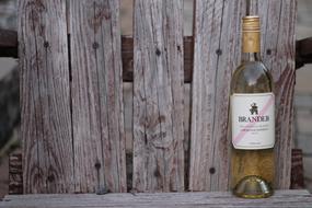 wine bottle against a wooden fence