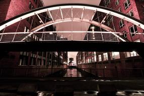 pink light over the bridge between houses at night