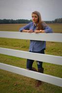 young Girl standing at fence in countryside