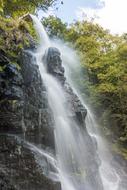 an incredible waterfall with rocks in the forest