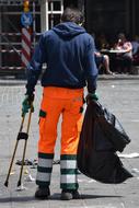 uniformed man picking Garbage