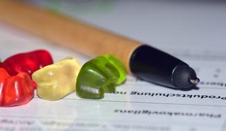 Close-up of the pen and colorful gummy bears on the black and white agenda