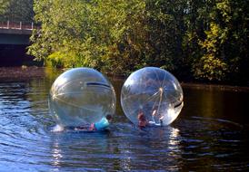 Kids plays in orbs on water