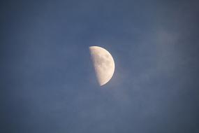 half of the moon in the blue sky