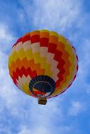 Beautiful and colorful flying hot air balloon under blue sky with white clouds