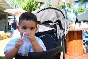 Baby boy holds plastic cap