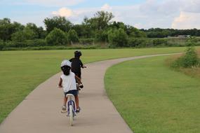 children ride bicycles in the park