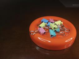 Close-up of the colorful clips, on the shiny, orange circle