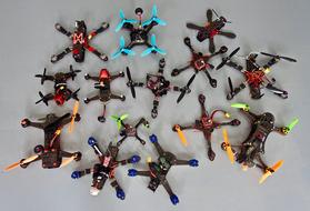 Different colorful quadcopters, on the grey surface