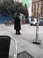 fat man in black coat and hat on Plaza