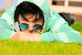 handsome man with glasses lying on the grass