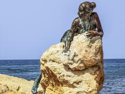 Statue of a girl at a stone