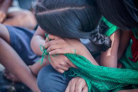 The girl shyly hides her face in her hands