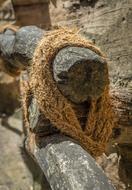 Close-up of the rope on the wooden railing, in sunlight