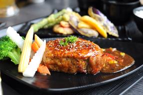 grilled steak in spicy sauce with vegetables