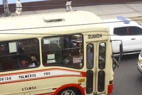 People in the colorful, old, retro bus, among the cars