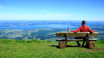 young boy sits on bench at gorgeous landscape