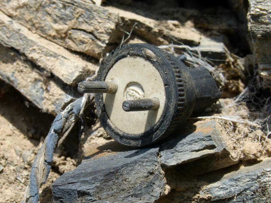 Close-up of the old plug on the rocks, in light