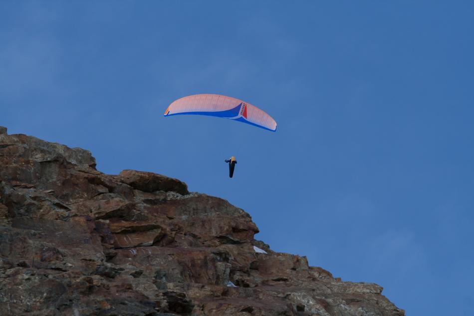 a man on a parachute at the cliff