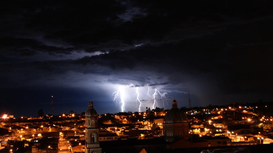 lightning flashing in the background of the city