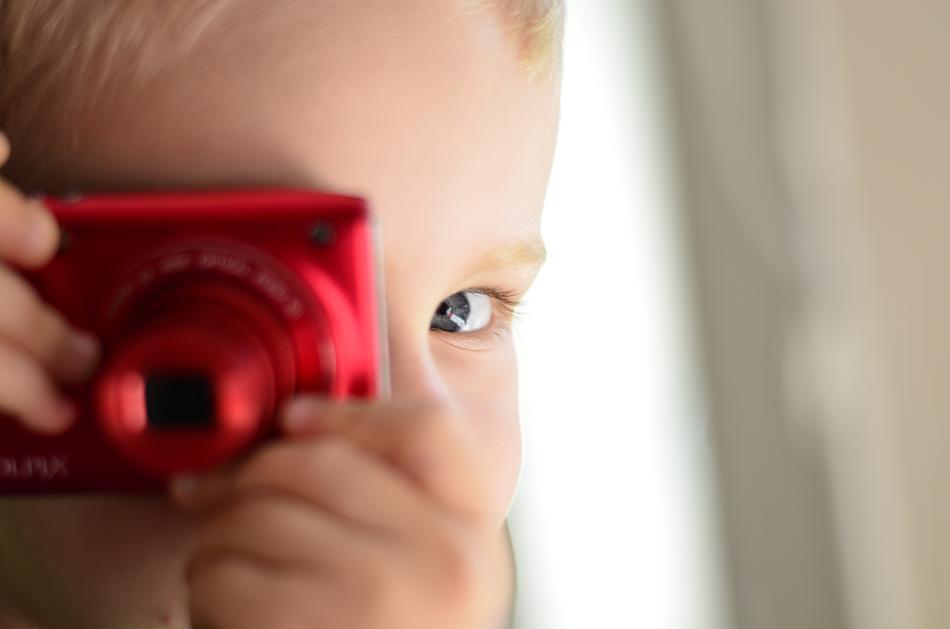 Child plays with red Camera
