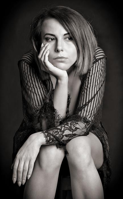 Black and white portrait of the sitting girl looking aside