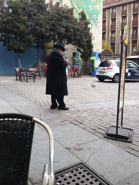 fat man in black coat and hat on Plaza