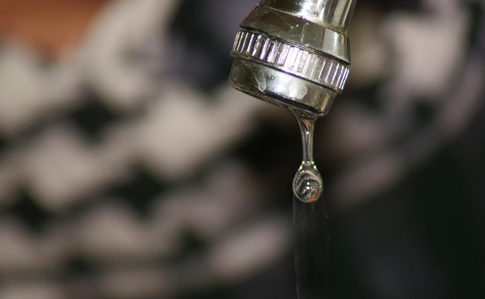 Close up of a falling drop of water from a faucet