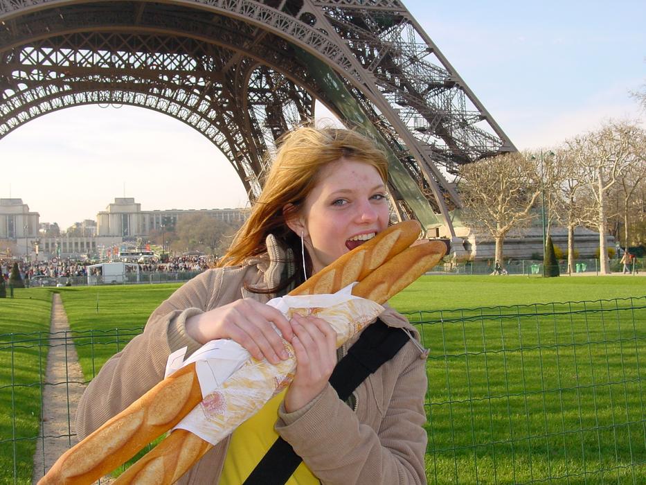 happy young girl with two Baguettes near eiffel tower, france, paris