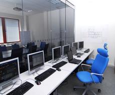 Interior of the office with computers with devices, and blue chairs