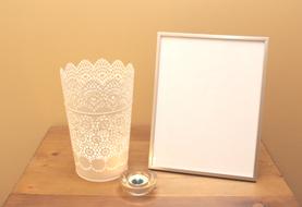 the white vase with the white frame on the table