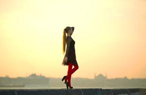 long hair girl in Red tights at sky in view of coastal city