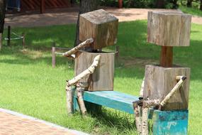 Wooden anthropomorphic figures on bench in park