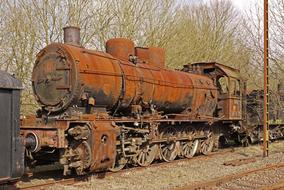 an iron train on tracks in the trees