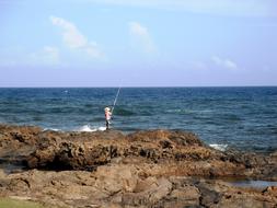 rock fisherman at sea