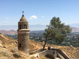 panoramic view of the ancient stone tower with a cross
