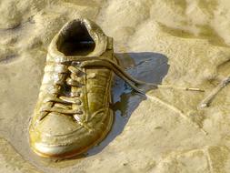 an old white sneaker in the sand