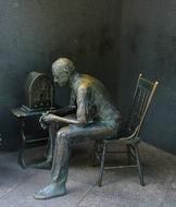 seated man on a chair as a bronze statue