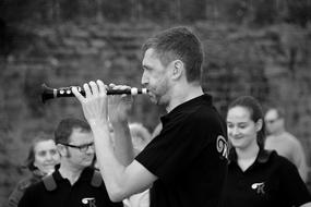 Black and white photo, with the profile portrait of the man, playing on the biniou